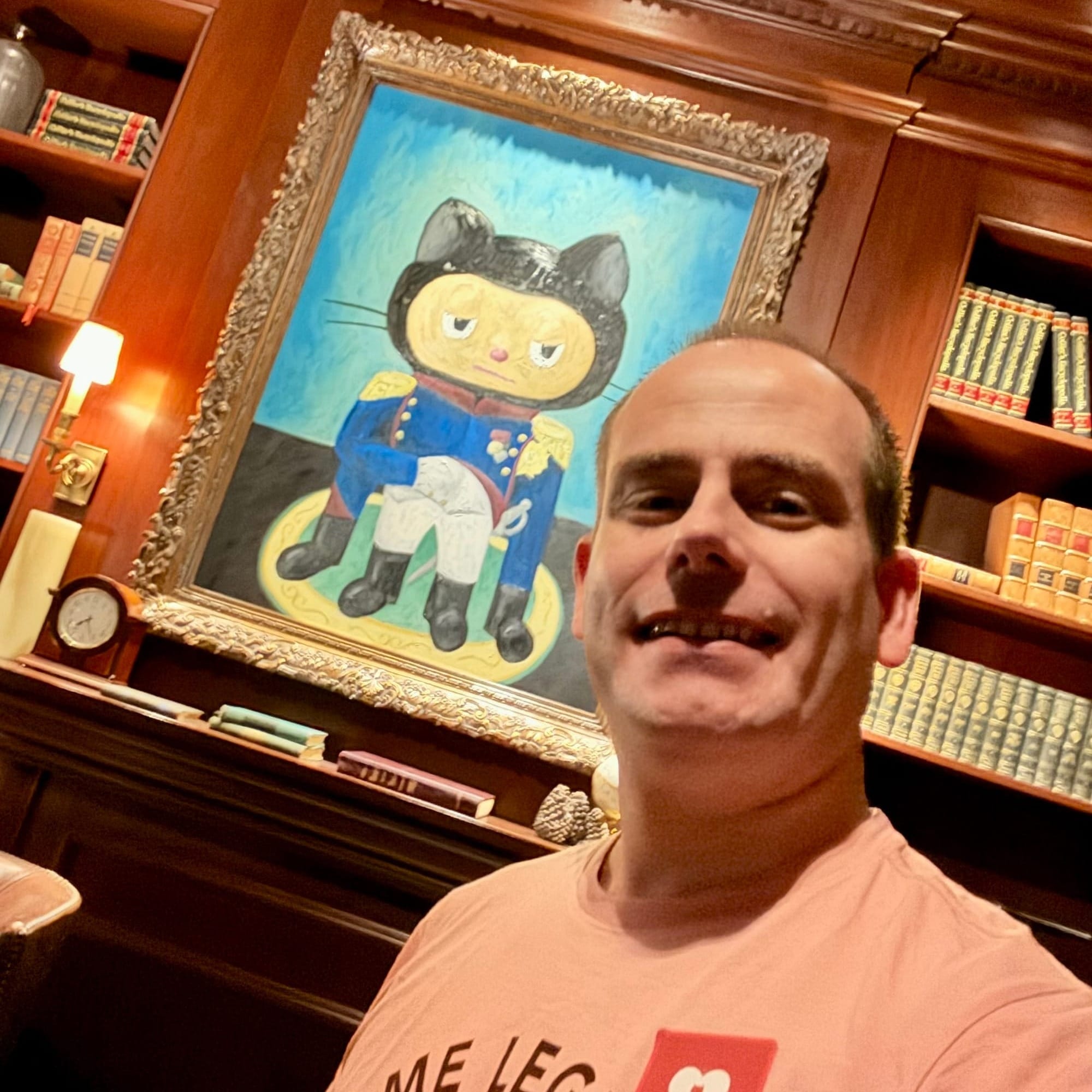 Picture of me standing in the secret room of GitHub in front of a painting of the GitHub mascotte Mona as Napoleon