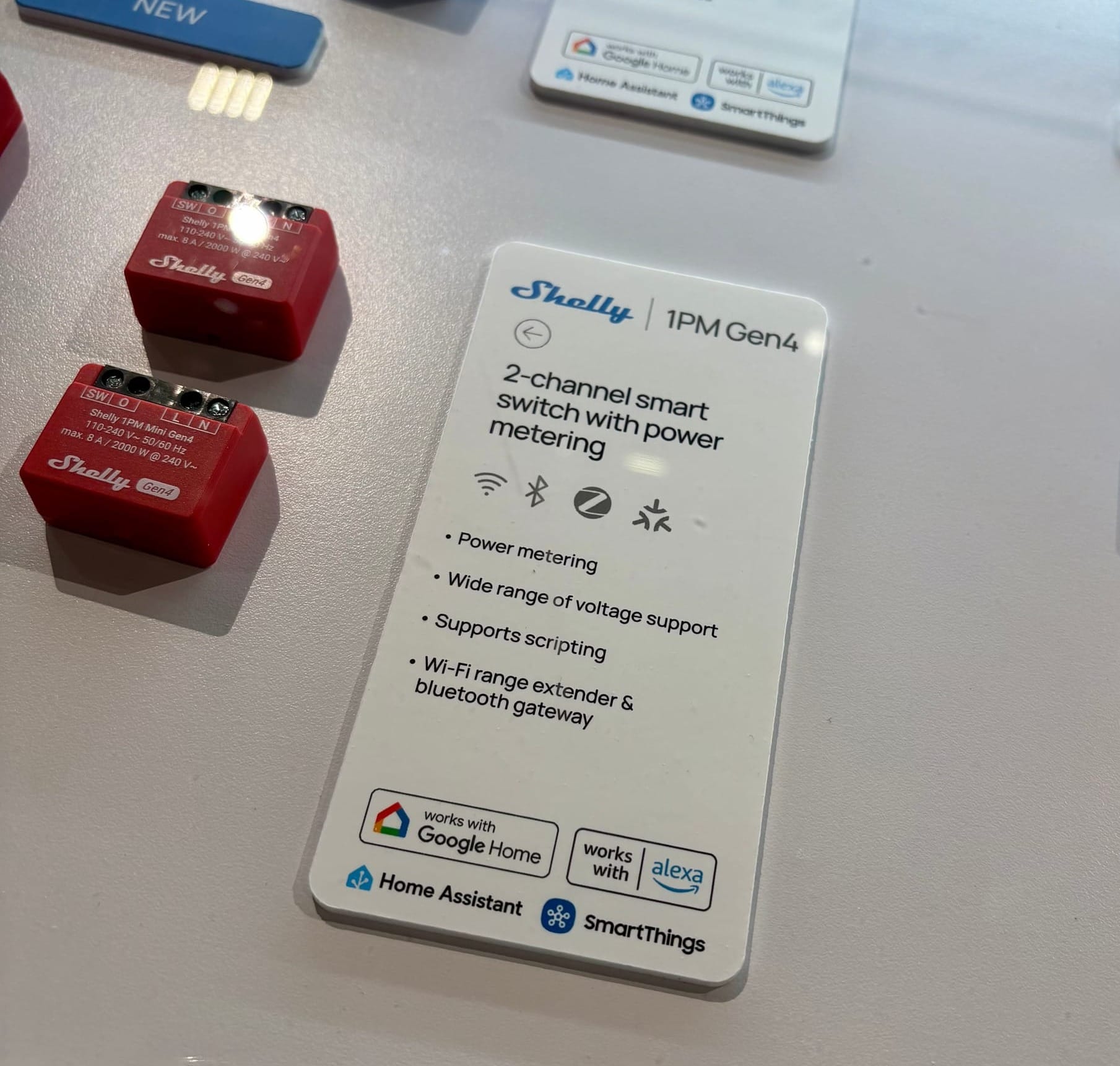 Photo of a Shelly smart switch that one can built into a wallsocket. The Home Assistant logo shows proudly on the information card next to the product.