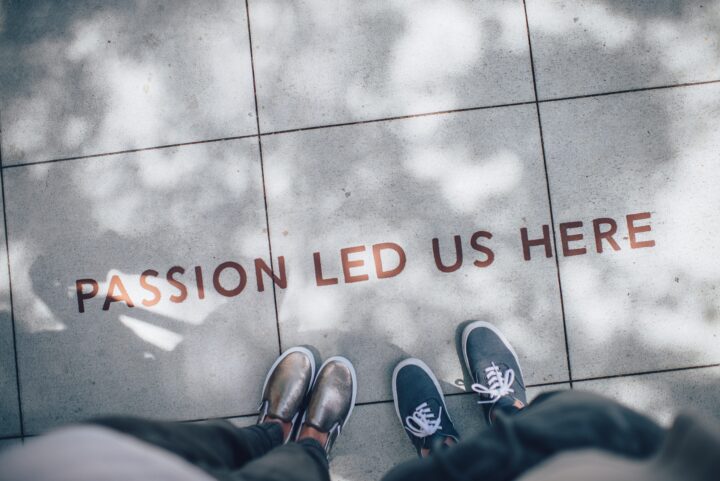 Picture of a pavement having written "Passion led us here" on it