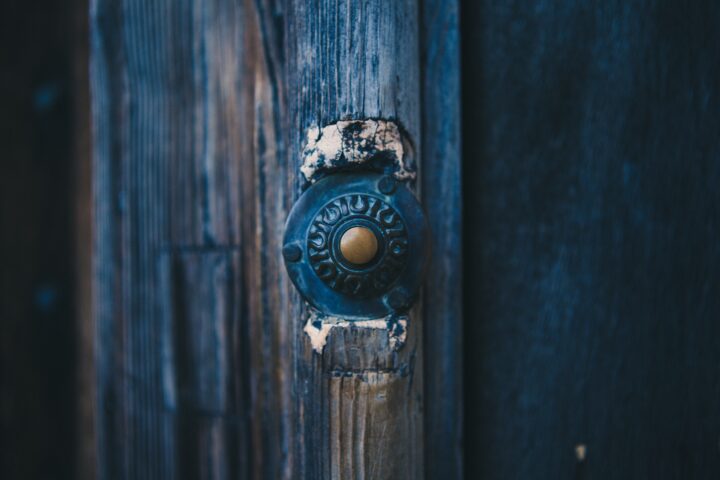 Old doorbell button near a door